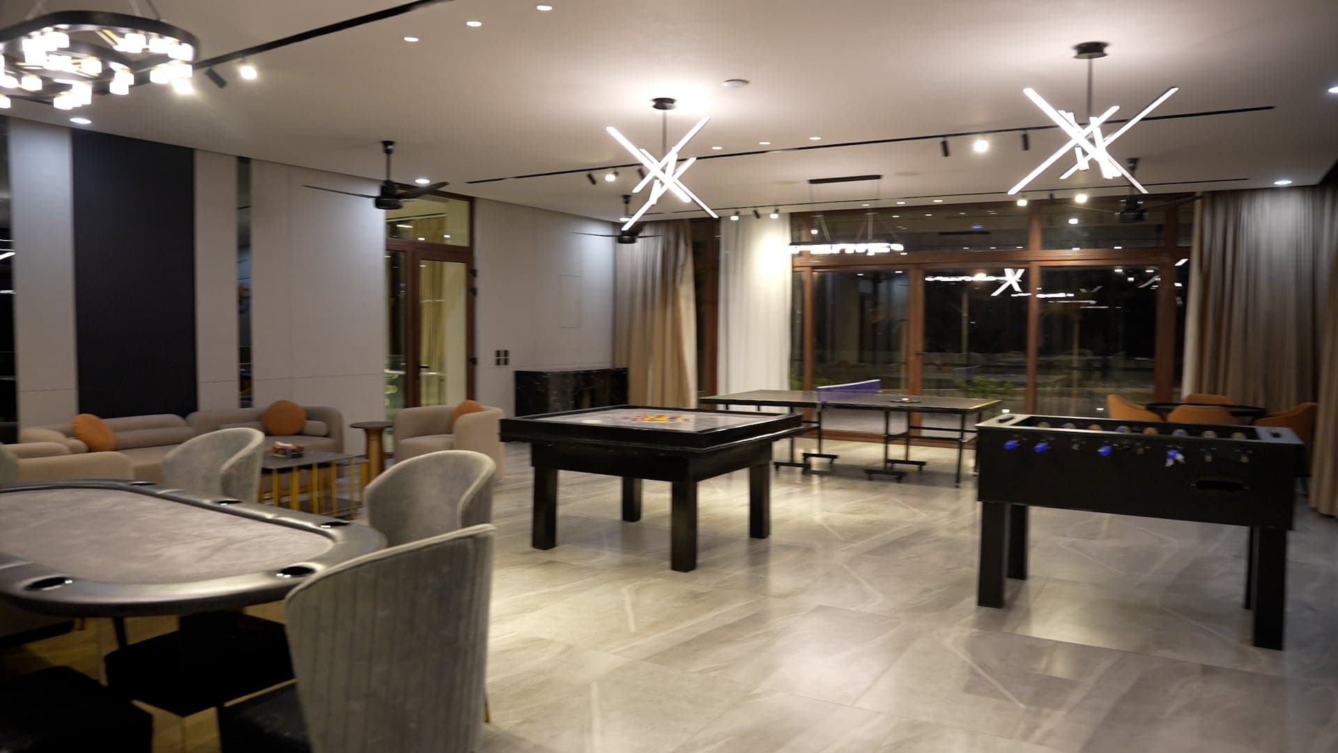 Games lounge with foosball, poker and table-tennis tables under starburst lighting at FHU Resorts Karachi