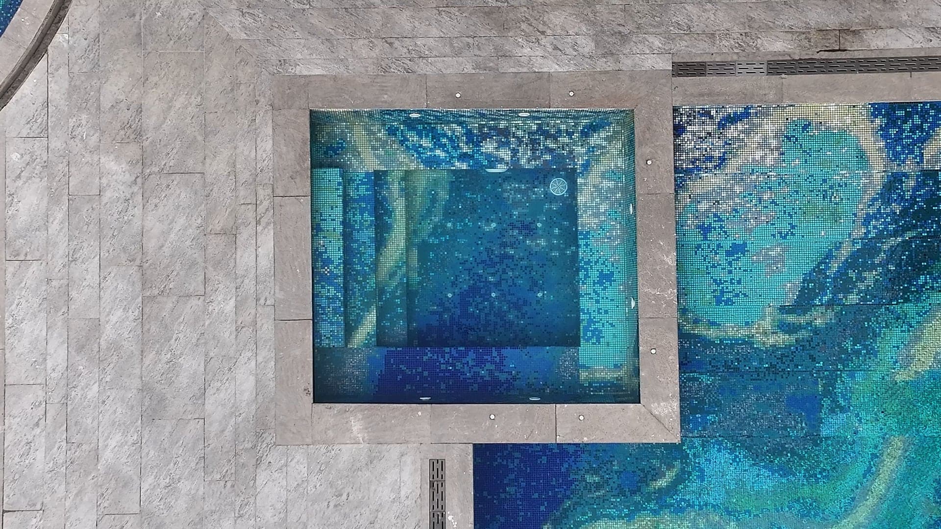 Blue glass-mosaic jacuzzi beside the main pool at FHU Resorts Karachi