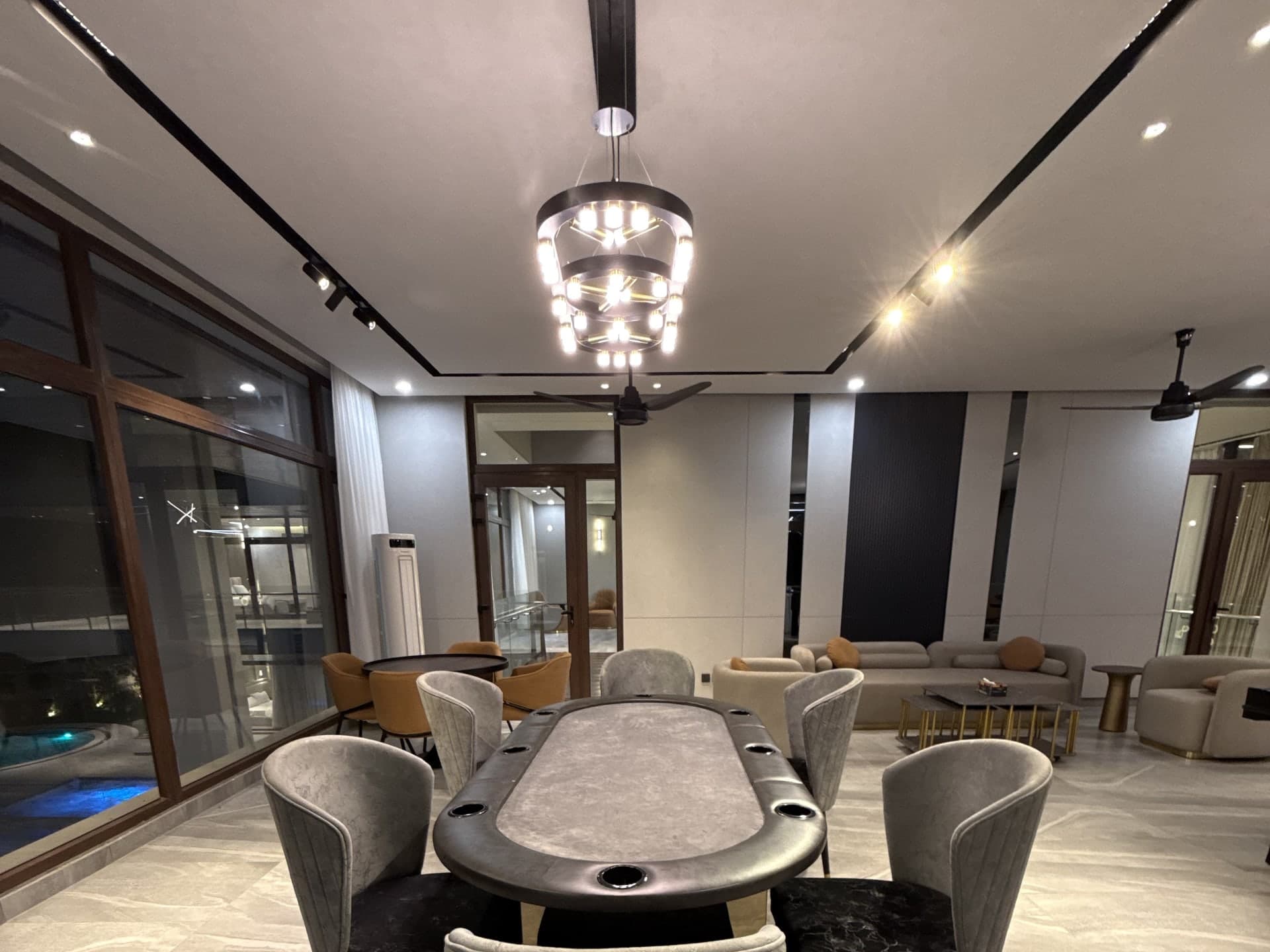 Oval poker table with grey velvet chairs in the games lounge at FHU Resorts Karachi