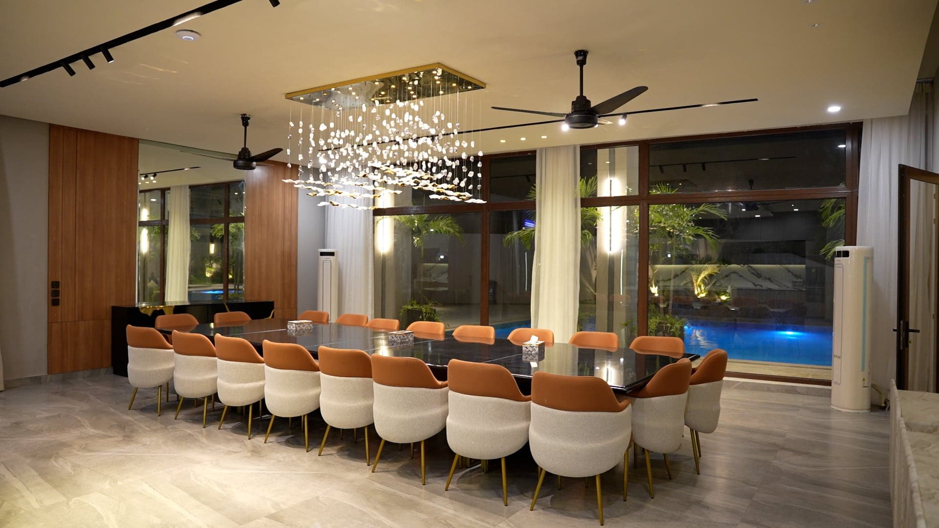 Grand dining hall with a crystal cascade chandelier and a poolside glass wall at FHU Resorts Karachi