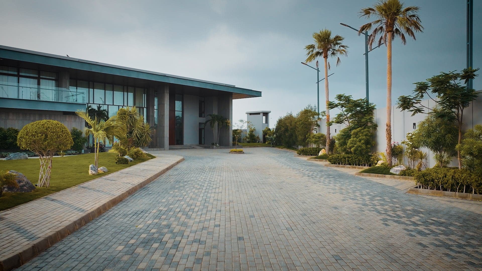 Paved arrival driveway lined with palms leading to the villa entrance at FHU Resorts Karachi