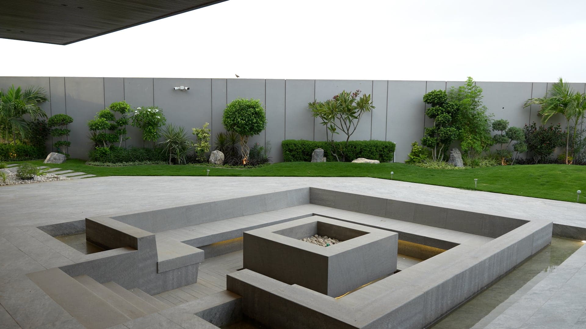 Sunken concrete fire-pit lounge set in a landscaped garden courtyard at FHU Resorts Karachi