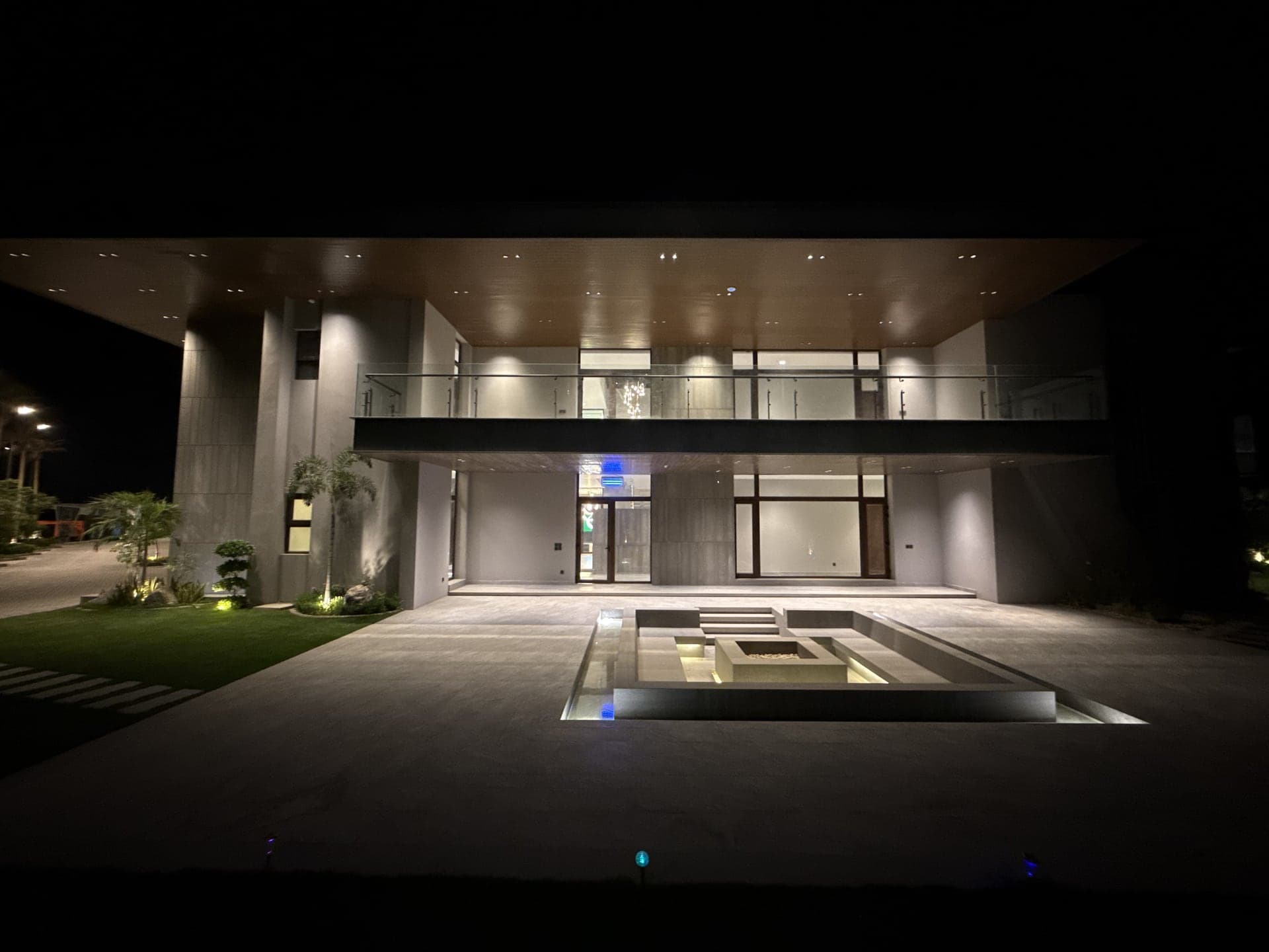 The villa and sunken courtyard floodlit against the night sky at FHU Resorts Karachi